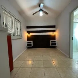 Hall de corredor com piso de cerâmica claro.