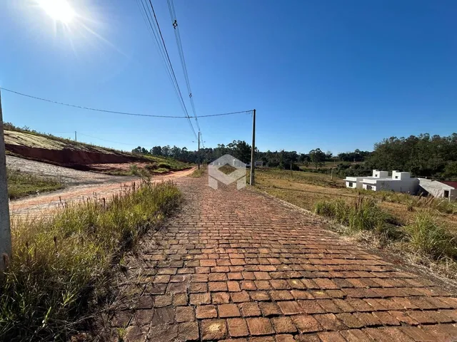 Uma estrada de tijolos se estende por uma paisagem rural sob um céu azul.