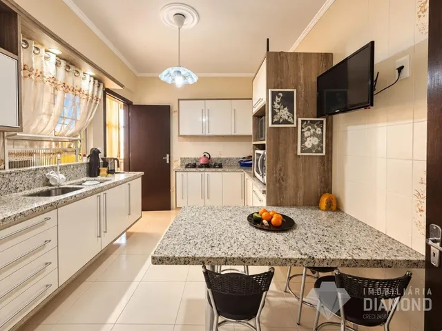 Foto de uma cozinha com armários e bancadas em um imóvel.