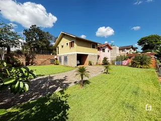 Fachada de uma casa em Lajeado, Brasil, com jardim gramado e entrada de cascalho.