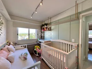 Quarto com cama e berço em um apartamento.