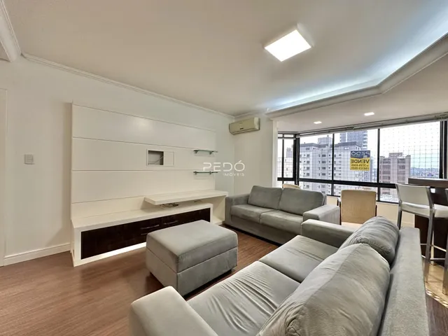Sala de estar com sofá e piso de madeira clara.