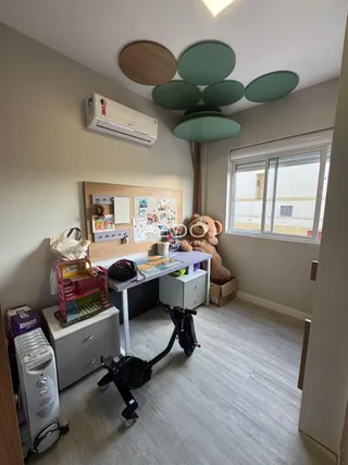 Quarto com cabeceira de madeira e espaço de trabalho em Lajeado.