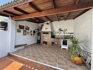 Sala de estar com teto de madeira e lareira em uma residência.
