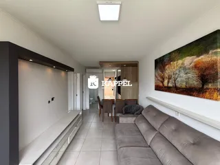 Uma sala de estar com sofá e uma pintura grande na parede.