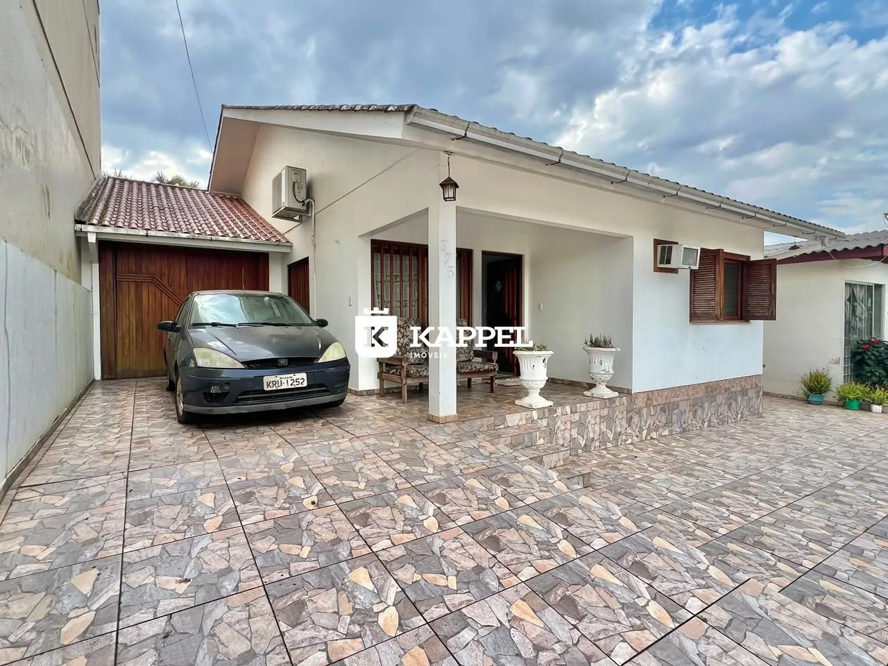 Fachada de uma casa em Lajeado, Brasil, com área externa pavimentada.