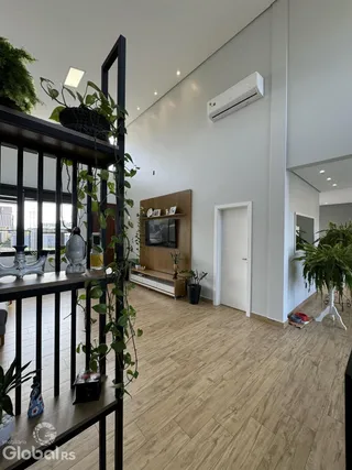 Ambiente interno moderno com piso de madeira e parede branca.