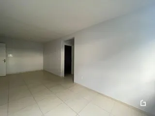 Vista interna de um corredor com piso de cerâmica clara.