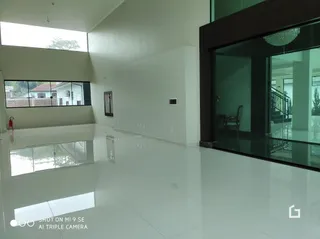 Interior de um espaço amplo com piso branco reflexivo.