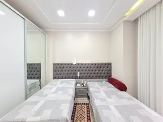 Quarto com duas camas de solteiro e cabeceira.