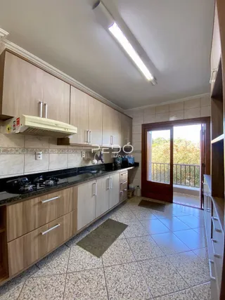 Foto de uma cozinha com armários de madeira e piso cerâmico.