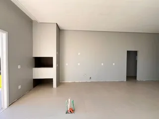 Vista interna de um ambiente amplo e vazio com paredes claras.