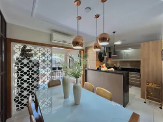 Vista de uma sala de jantar integrada a uma cozinha moderna.