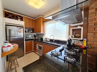 Foto de uma cozinha com armários de madeira e bancada de granito.
