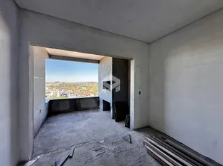 Interior de um espaço em construção com vista para a paisagem externa.
