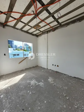 Foto de um cômodo interno com teto de concreto aparente e paredes brancas.