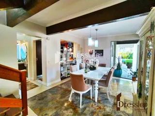 Interior de uma sala de jantar com piso de cerâmica e vigas de madeira.