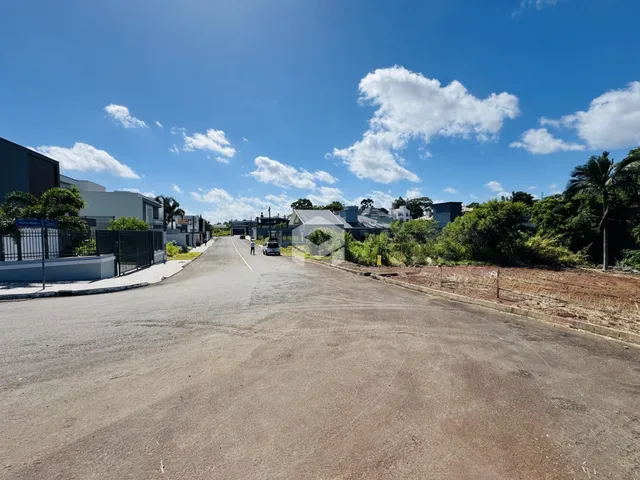 Vista da rua e casas em Lajeado, Brasil, sob um céu azul claro.