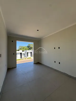 Hall de entrada com paredes brancas e piso de cerâmica.