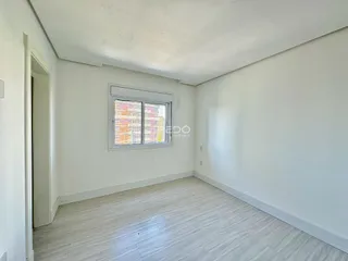 Interior de um cômodo com paredes brancas e piso claro.