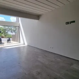 Ambiente interno com piso de concreto e teto suspenso em uma propriedade.