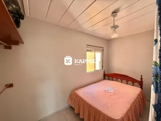 Quarto com cama de madeira e janela em um imóvel no Brasil.