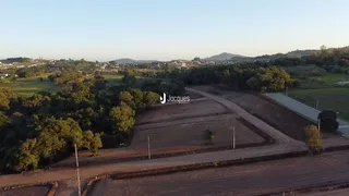 Vista aérea de um terreno com vegetação densa e estradas de terra.