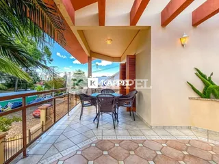 Vista de um pátio externo com mesa e cadeiras em uma residência.