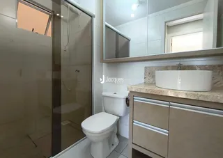 Foto de um banheiro com louças sanitárias e bancada em um imóvel.