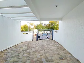 Vista de um pátio pavimentado com blocos de concreto em uma área externa.