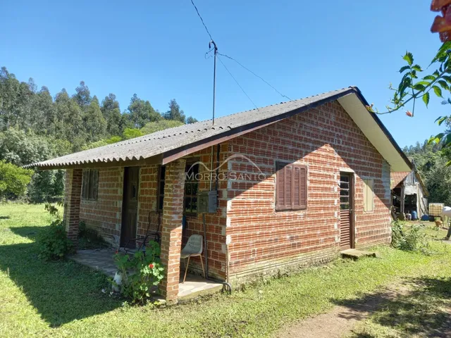 Fachada de uma casa de tijolos vermelhos em Lajeado, Brasil, com gramado ao redor.