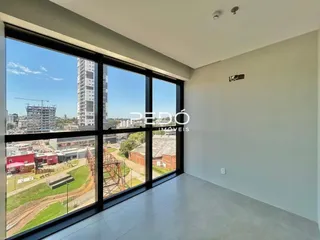Sala com grandes janelas que oferecem vista para o quintal externo.