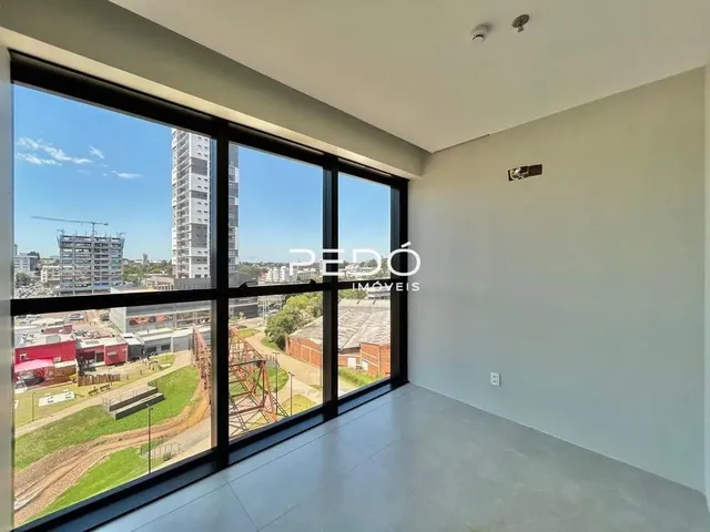Sala com grandes janelas que oferecem vista para o quintal externo.