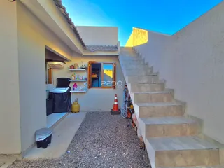 Fachada de uma residência em Lajeado, Brasil, com escadaria externa e pátio de cascalho.