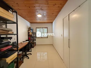 Foto de um escritório com estantes e mesa de trabalho em um ambiente interno.