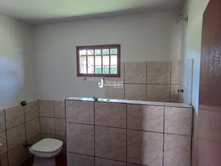 Foto de um ambiente interno com revestimento de cerâmica e um vaso sanitário.