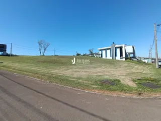 Fachada de uma casa branca situada em uma colina com gramado verde.