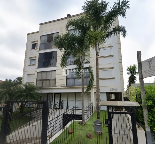 Fachada de um prédio residencial em Lajeado, Brasil, com cerca e vegetação.