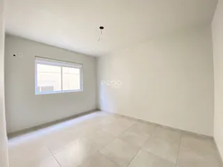 Ambiente interno de uma sala com piso de cerâmica e paredes brancas.