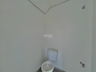 Foto de um corredor com um vaso sanitário branco.