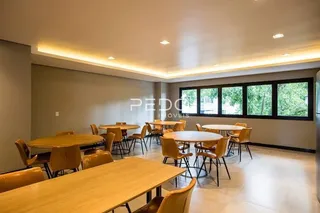 Uma sala de jantar com mesas e cadeiras de madeira.