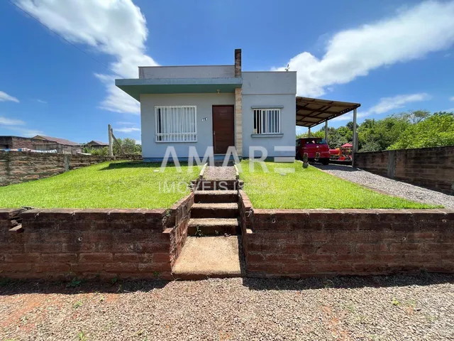 A fachada de uma casa em Lajeado, Brasil, com jardim gramado e muro de tijolos.