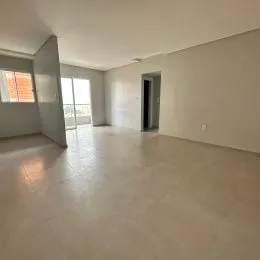 Ambiente interno amplo com piso claro e paredes brancas.
