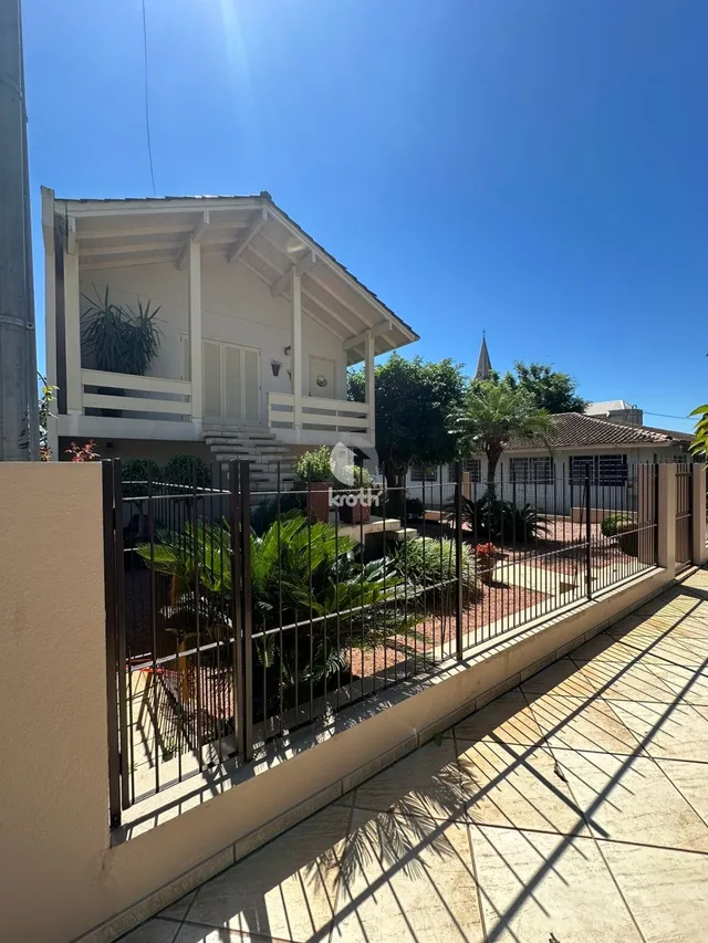 Fachada de uma casa em Lajeado, Brasil, com cerca e jardim frontal.