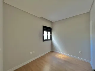 Vista interna de um cômodo com piso de madeira clara.