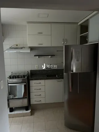 Foto de uma cozinha com armários brancos e eletrodomésticos de aço inoxidável.
