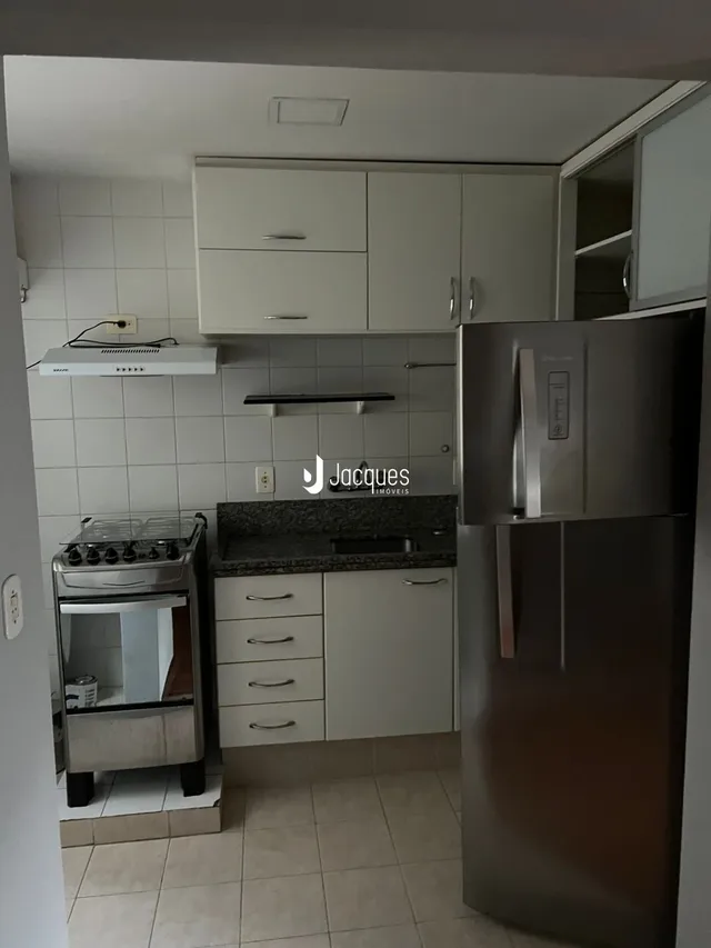 Foto de uma cozinha com armários brancos e eletrodomésticos de aço inoxidável.