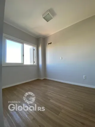 Ambiente interno de uma sala com piso de madeira clara e paredes brancas.