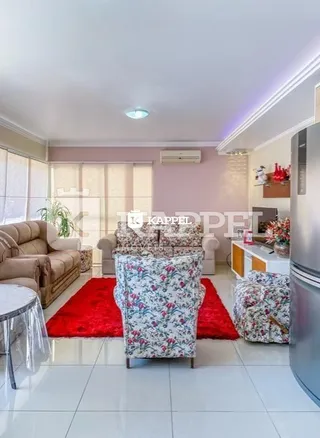 Foto de uma sala de estar com sofá e tapete vermelho.