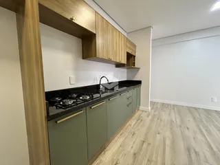 Vista da cozinha com armários e bancada escura.